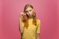 Disappointed girl showing small size with pity on pink studio background. Young woman showing measurement with fingers Royalty Free Stock Photo