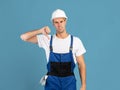 Disappointed Handyman In Hardhat And Coveralls Showing Thumb Down Gesture At Camera