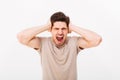 Disappointed man 30s grabbing his head or covering ears while sc Royalty Free Stock Photo