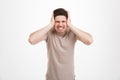 Disappointed man 30s grabbing his head or covering ears while sc Royalty Free Stock Photo