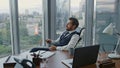 Disappointed manager reading message on smartphone sitting in luxury office. Royalty Free Stock Photo