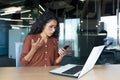 Disappointed and sad woman looking at phone screen, reading bad news online, Hispanic business woman working inside Royalty Free Stock Photo