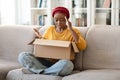 Disappointed unhappy black woman unpacking parcel at home Royalty Free Stock Photo