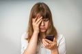 Disappointed woman holding and looking on mobile phone Royalty Free Stock Photo