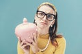 Disappointed woman holding a money box with her savings