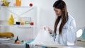 Disappointed woman looking at hole on blouse after ironing, lack of experience