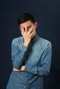 Disappointed young Asian man covering his face by palm Royalty Free Stock Photo