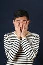 Disappointed young Asian man covering his face by palms Royalty Free Stock Photo