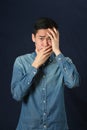 Disappointed young Asian man covering his face by palms Royalty Free Stock Photo