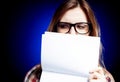 Disappointed young girl with nerd glasses holding