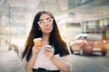 Disappointed Young Woman Holding Smartphone and Coffee Cup Royalty Free Stock Photo