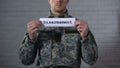 Disarmament word written on sign in hands of male soldier, end of war, peace