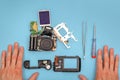 Disassembled camera, tools and repairman's hands