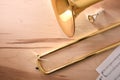 Disassembled golden trombone and scores on a wooden table