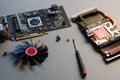 Disassembled graphics card XFX GPU AMD fan screws screwdriver on a table,