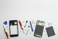 Disassembled mobile phone and repair tools on background, flat lay