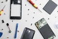 Disassembled mobile phone and repair tools on background, flat lay