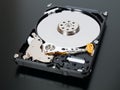 Disassembled open hard disk drive HDD of computer or laptop lies on black matte surface. IT closeup. ÃÂ¡omputer hardware and Royalty Free Stock Photo