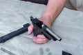 Disassembled pistol in hand. The barrel of a pistol without a box