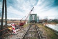 Disassembly and cutting of the old steel railway bridge and rusty rails