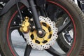 Disc brake of an electric motorcycle. Chrome disc brakes with a modern design and a gold color caliper installed on an electric Royalty Free Stock Photo