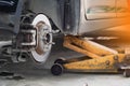 Disc brake of the vehicle for repair,Seal a leaking car tire.Car brake repairing in garage.Dirty Yellow Hydraulic Jack Forklift