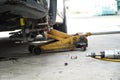 Disc brake of the vehicle for repair,Seal a leaking car tire.Car brake repairing in garage.Dirty Yellow Hydraulic Jack Forklift
