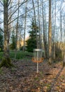 a disc golf hole on green grass with birch grove in background, disc golf basket in a park Royalty Free Stock Photo