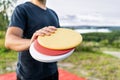 Disc golf player with frisbee equipment in park course. Man playing discgolf. Outdoor sport tournament. Summer landscape.