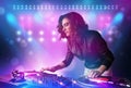 Disc jockey mixing music on turntables on stage with lights and Royalty Free Stock Photo