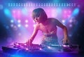 Disc jockey mixing music on turntables on stage with lights and