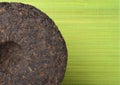 Disc of puer tea on green background Royalty Free Stock Photo