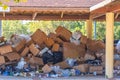 Discarded brown colored corrugated paper carton boxes piled up for recycle process. Under a wooden canopy, ready for removal and Royalty Free Stock Photo