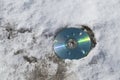 Discarded compact disc on snow outdoors Royalty Free Stock Photo