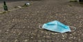 Discarded Covid face mask laying on the street Royalty Free Stock Photo