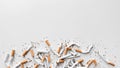 Discarded crushed broken cigarettes and scattered tobacco on white background, representing cessation and the end of