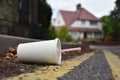 Discarded drinks container lying at the edge of an urban street