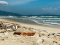 Discarded garbage on the shore of a beautiful sandy beach. Sea shore with garbage Royalty Free Stock Photo