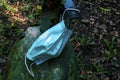 Discarded health mask hanging on the end of a green rusty iron Royalty Free Stock Photo