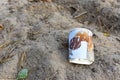 Discarded Paper coffee cup on ground. Disposable coffee cup on sand. The problem of environmental pollution. Pile of abandoned