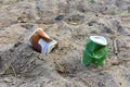 Discarded Paper coffee cup on ground. Disposable coffee cup on sand. The problem of environmental pollution. Pile of abandoned