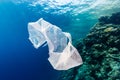 Discarded plastic bag drifting past a tropical coral reef