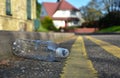 Discarded plastic bottle lying at the edge of an urban street