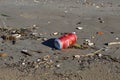 Discarded red beverage can polluting sandy beach environment Royalty Free Stock Photo