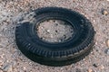 Discarded tire lying on the beach, environmental contamination