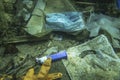 Discarded used medical face mask along with other plastic debris lies on the seabed. Becici, Budva Municipality, Montenegro