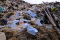 Discarded used medical face masks along and garbage trash with other plastic debris lies