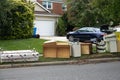 Discarded wooden furniture and an old bed lined up by the curb near a street waiting for trash pickup Royalty Free Stock Photo