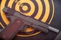 Discharged handgun lying on back of dartboard target. Toned