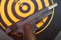 Discharged handgun lying on back of dartboard target. Toned